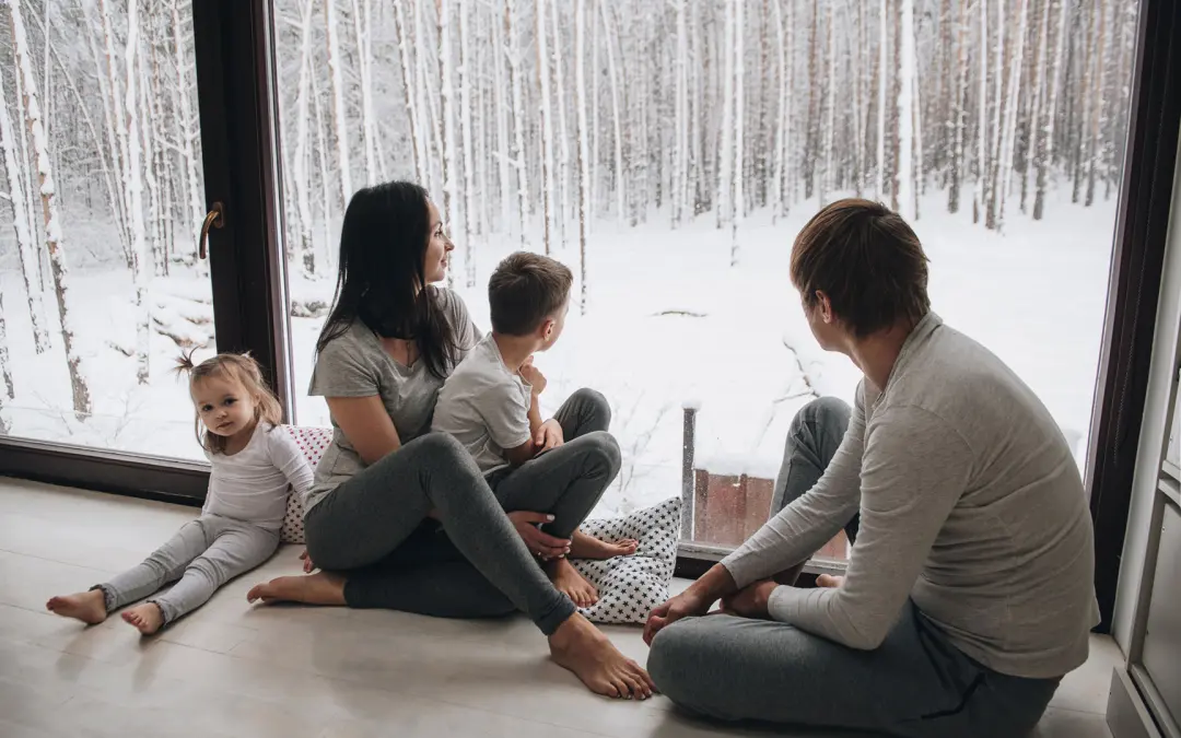 Family looking out window at snowy scene