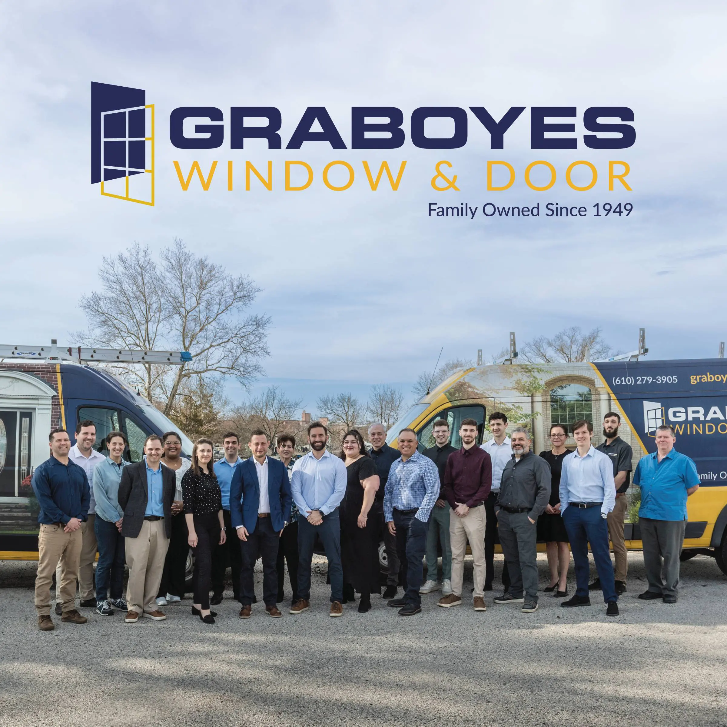 Group photo of the whole Graboyes team in front of company branded work vans.