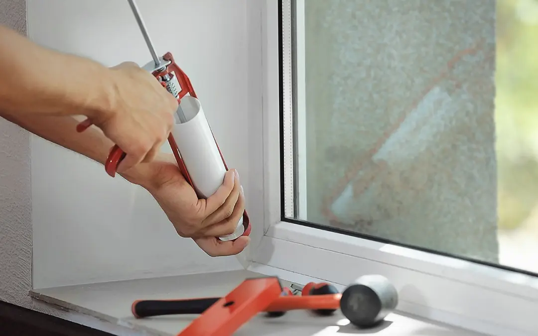 closeup of someone caulking a window.